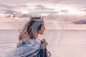 Fashion model portrait. young pretty woman with crown outdoors a