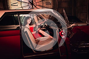 Fashion model in red dress in a retro car invites you to come in photo