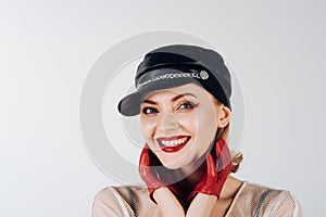Fashion model with stylish hairdo. Rock woman with blonde hair on grey background. Girl in leather cap. Cool look of