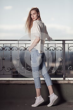 Fashion model. Summer look. Jeans, sneakers, sweater.