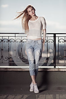 Fashion model. Summer look. Jeans, sneakers, sweater.