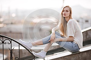 Fashion model. Summer look. Jeans, sneakers, sweater.