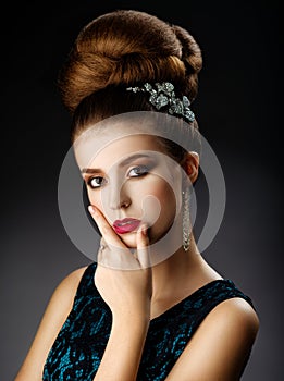 Fashion model touches face. Updo.