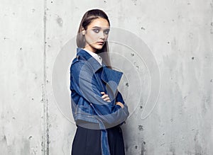 Fashion model wearing denim jacket and long black skirt posing in studio