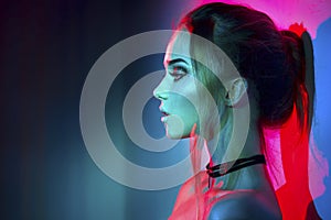 Fashion model woman in colorful bright lights posing