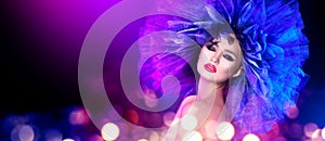 Fashion model woman in colorful bright lights posing. Portrait of beautiful girl with trendy makeup and colorful hairdo