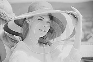 Fashion model woman fece close up. Face woman wiht happy emotion. Woman in red hat posing on sunny day on natural