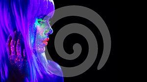 Fashion model woman in neon light. Beautiful model girl with colorful bright fluorescent makeup isolated on black