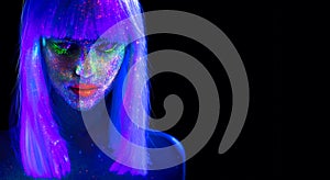 Fashion model woman in neon light. Beautiful model girl with colorful bright fluorescent makeup isolated on black. Ultraviolet