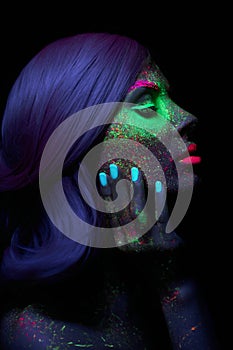 Fashion model woman in neon light bright fluorescent makeup, long hair, drop on face. Beautiful model pink hair girl colorful make