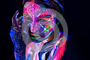 Fashion model woman in neon light, portrait of beautiful model girl with fluorescent make-up, Body Art design of female