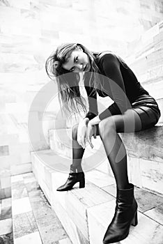 Fashion model. Young blond caucasian woman dressed in black clothes. Beautiful caucasian girl posing outdoor in Milan, Italy.