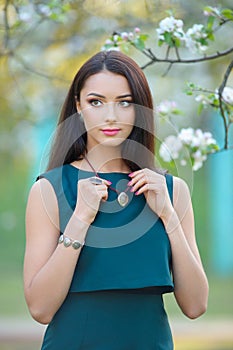 Fashion model young woman at blooming spring garden with luxury