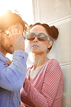 Fashion models couple wearing sunglasses. Sexy woman and handsome young man portrait over light background. Attractive