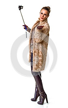 Fashion-monger on white with selfie stick blowing air kiss