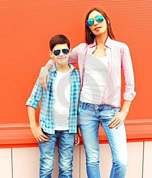 Fashion mother with son teenager in a sunglasses, checkered shirt