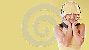 Fashion, music headphones and woman portrait with mockup space isolated on yellow background. Face of a happy asian girl