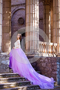 Fashion outdoor photo of beautiful sensual girl with dark hair in elegant dress posing in ancient architecture.