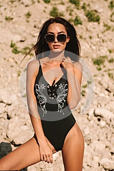 Woman with dark hair in elegant swimming suit and accessori photo