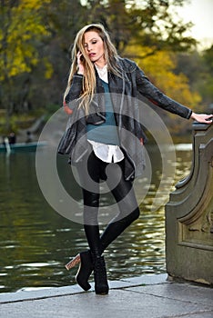 Fashion outdoor photo of beautiful woman wearing coat and leggings posing against the