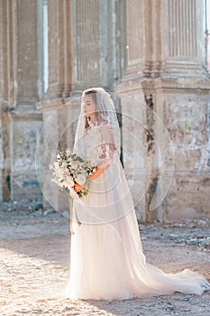 Pretty bride woman in elegant white lace dress with wedding bouquet
