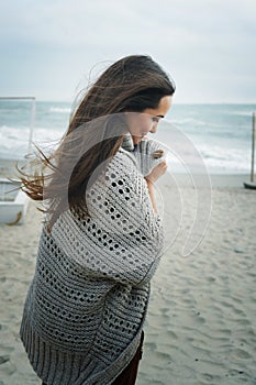 Fashion pensive woman portrait walking alone on a sea beach