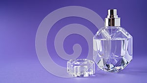 Fashion perfume in glass bottle on purple background. Diamond bottle shape. Transparent bottle. Crystal. Isolated