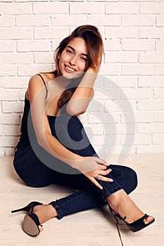 Fashion photo of beautiful smiling girl with dark hair wearing jeans