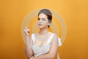 Fashion photo of a beautiful young woman in a pretty dress over white background