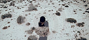 Fashion Photo. Girl in black clothes in the desert with a bouque