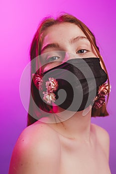 Fashion photo of a girl in a mask of flowers