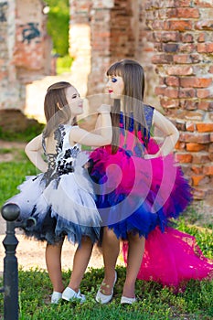 Fashion photo of two beautiful girls on a background of brick ru