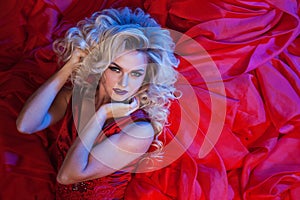 Fashion photo of young magnificent woman in red dress. Studio portrait