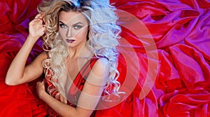 Fashion photo of young magnificent woman in red dress. Studio portrait