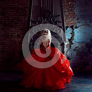 Fashion photo of young magnificent woman. Running towards camera. Seductive blonde in red dress with fluffy skirt