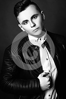 Fashion photo of young model man on black background. Boy posing. Sports guy. Studio photo. Black and white