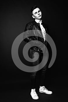 Fashion photo of young model man on black background. Boy posing. Sports guy. Studio photo. Black and white