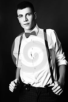 Fashion photo of young model man on black background. Boy posing. Studio photo. Black and white