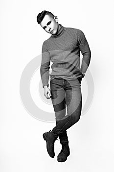 Fashion photo of young model man on white background. Boy posing. Sports guy. Studio photo. Black and white