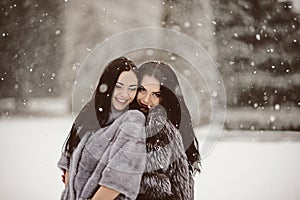 fashion photo of young women in winter landscape