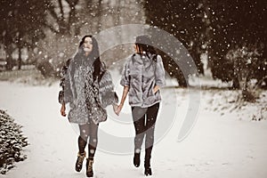 fashion photo of young women in winter landscape