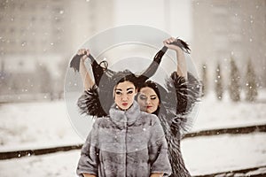 fashion photo of young women in winter landscape