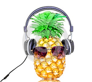 Fashion pineapple with sunglasses and black gray headphones listens to music isolated white background
