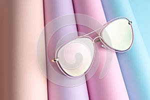 Fashion of pink Sunglasses put on colorful paper background