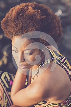 Fashion portrait of attractive black young model woman with ethnic afro hair style and african dress. Beautiful girl viewed from