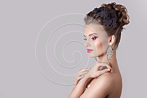 Fashion portrait of a beautiful attractive girl with a gentle elegant evening wedding hairstyles high and bright make-up