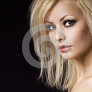 Fashion portrait. Beautiful blonde woman with professional makeup and hairstyle, over black. Vogue style model photo