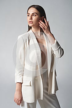 Fashion portrait of beautiful brunette woman in white jacket