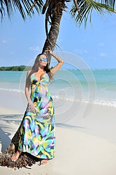 Fashion portrait of beautiful elegant woman near palm tree on a