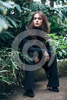 Fashion portrait of beautiful stylish woman relax in garden greenhouse